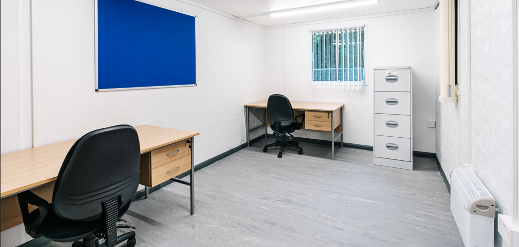 white interior of a portable office cabin with furniture